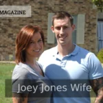 Joey Jones wife and Meg Garrison Jones smiling in front of a brick home.